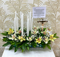 Arreglo para novenario con orquídeas, velas e imagen de Cristo en Bucaramanga