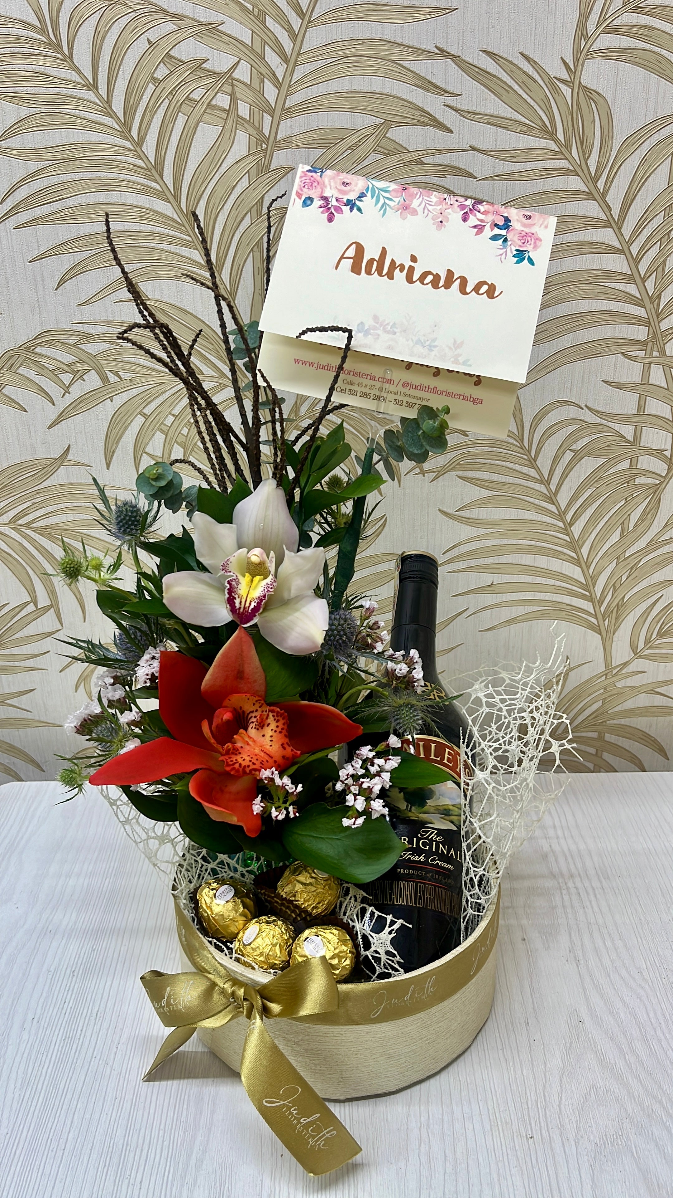 Detalle floral con orquídeas, chocolates Ferrero Rocher y licor en Bucaramanga